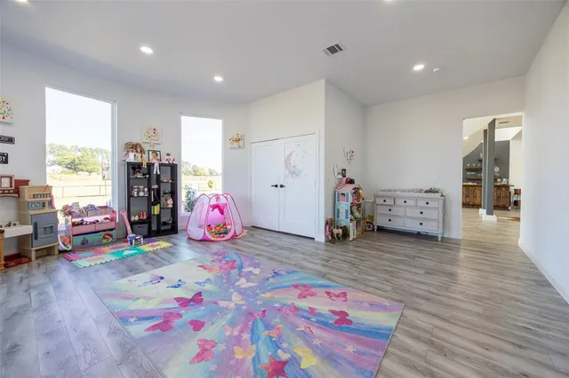 a playing room with furniture and a wooden floor