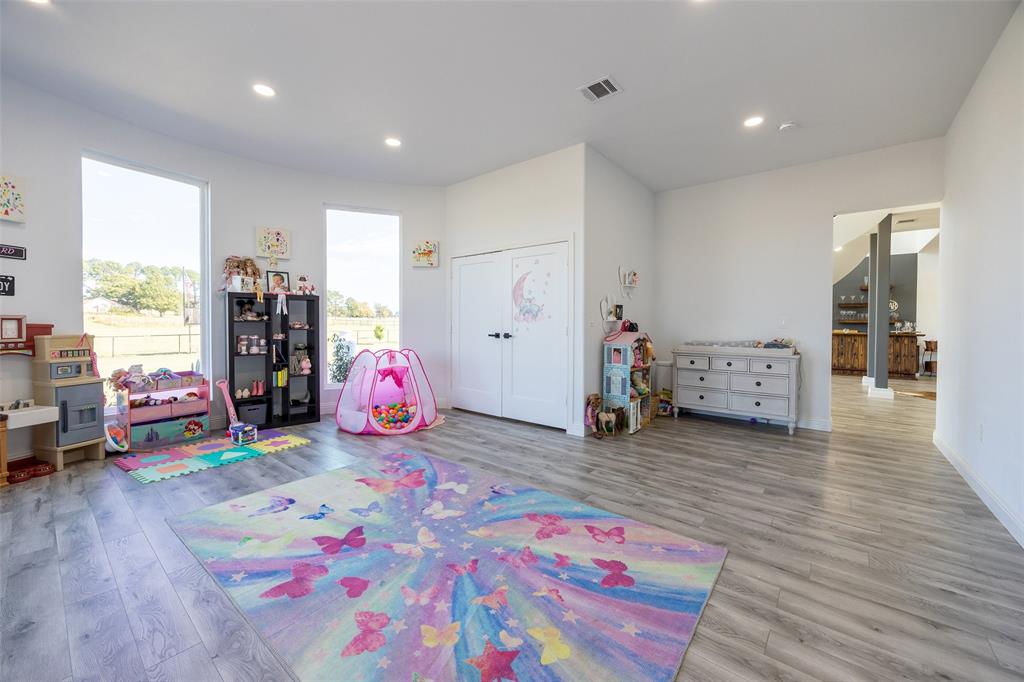 2630 Rockhill Road Aubrey, TX 76227 - Photo 15 of 38 a bedroom with furniture and a wooden floor