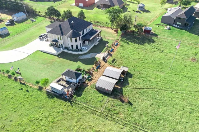 an aerial view of a house with a garden and lake view