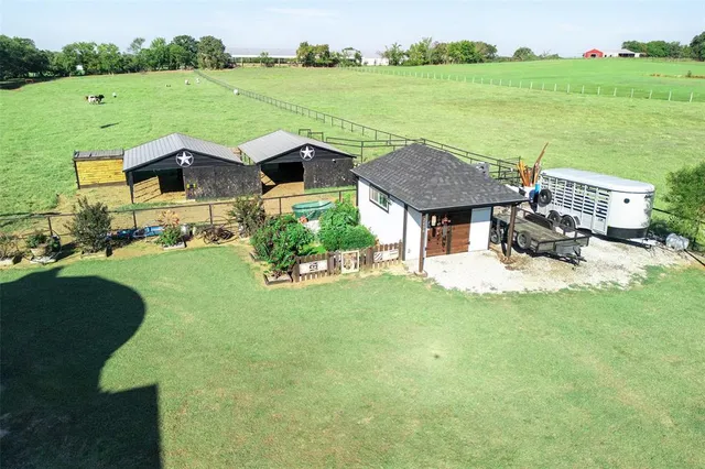 a view of a house with big yard and a fountain