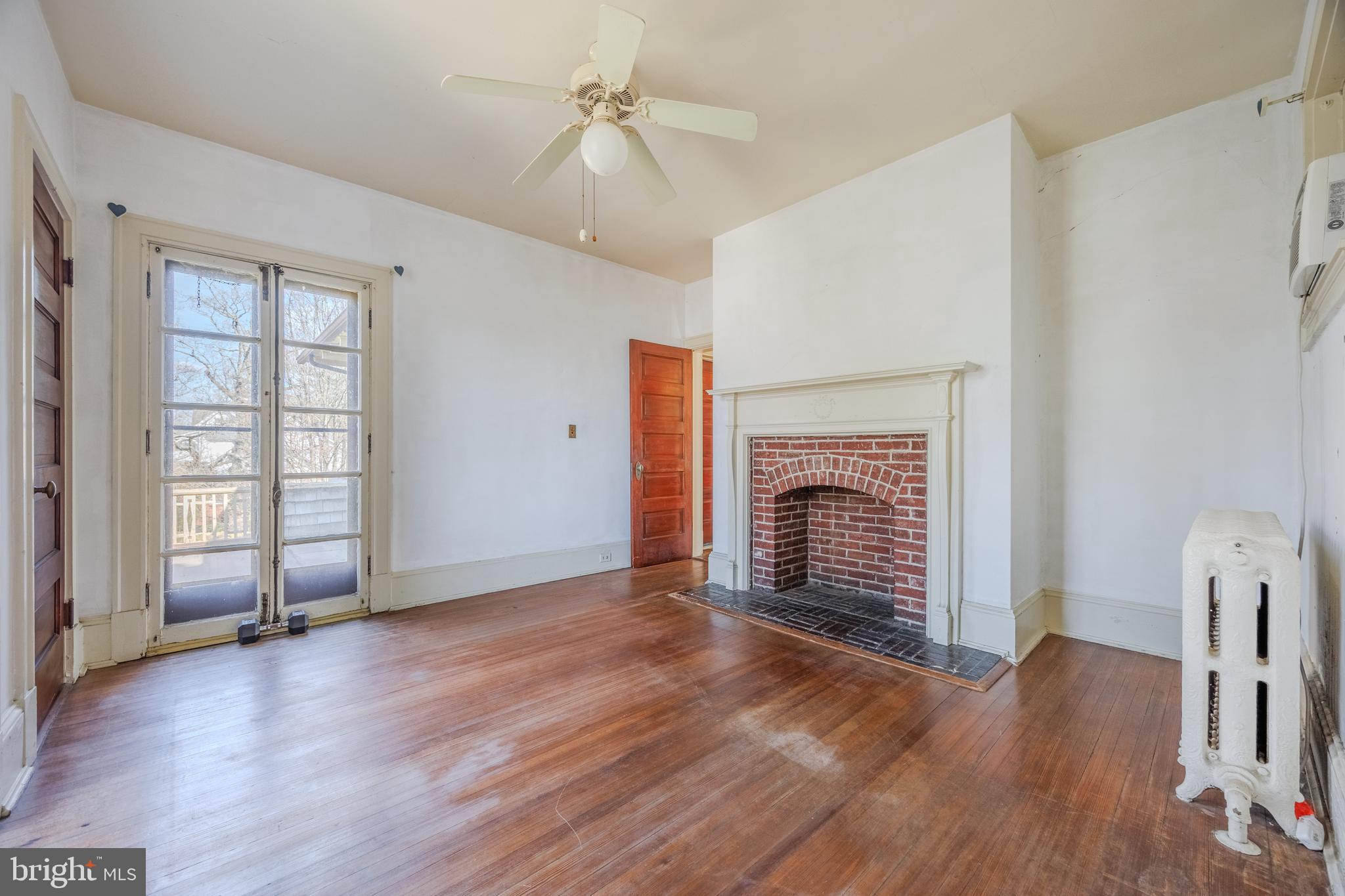 242 East Main Street Elkton, MD 21921 - Photo 30 of 53 an empty room with wooden floor fireplace and windows
