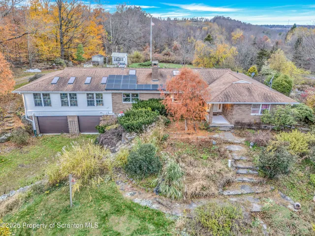 a view of a big house with a big yard and large tree
