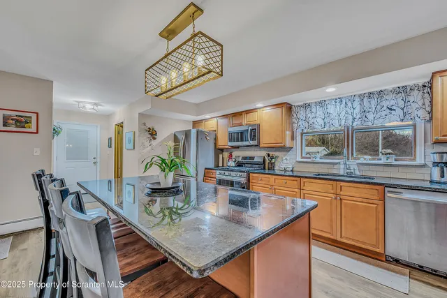 a dining room filled chandelier and wooden floor