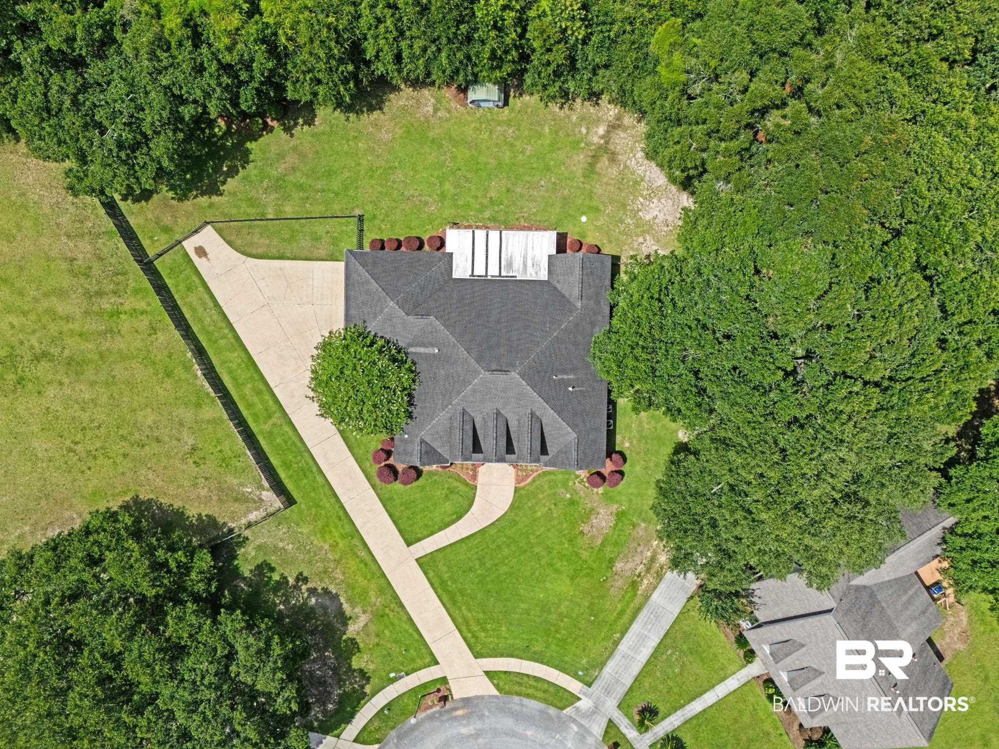 3176 Cedar Court Mobile, AL 36619 - Photo 33 of 33 Aerial property view featuring a dark shingle roof, extensive green lawn, and mature perimeter trees
