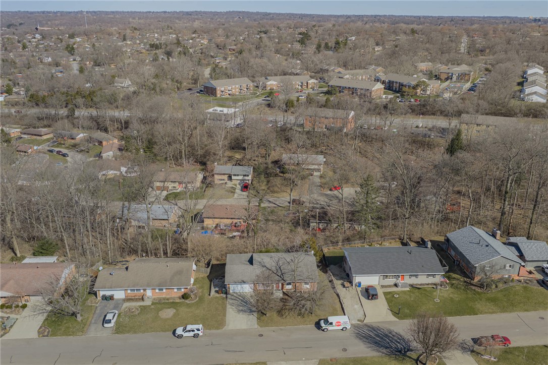 6300 Carnation Road Dayton, OH 45449 - Photo 2 of 35 An aerial view captures the layout of suburban homes and their surrounding natural landscape.