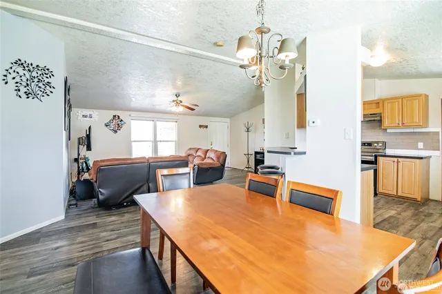 a large living room with stainless steel appliances kitchen island granite countertop furniture and a wooden floor