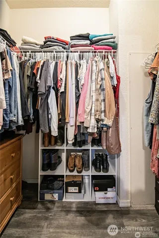 a view of walk in closet with clothes and shoes