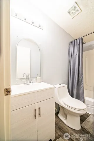 a bathroom with a toilet sink and mirror