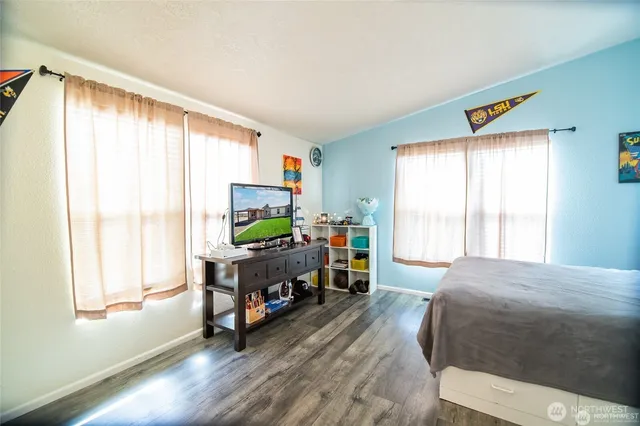 a bedroom with a bed and large windows