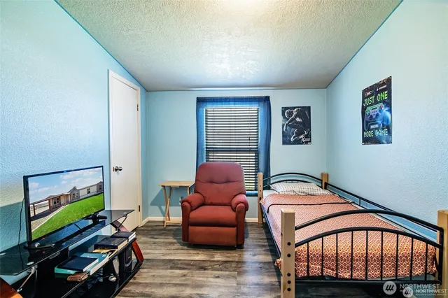 a bedroom with furniture and wooden floor