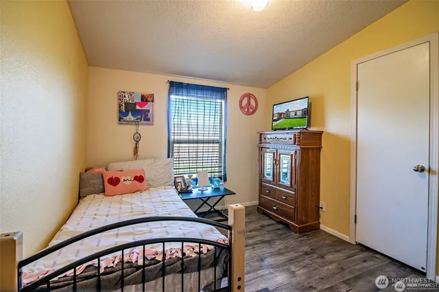 a bedroom with a bed and wooden floor