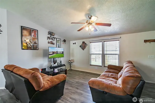 a living room with furniture ceiling fan and a window