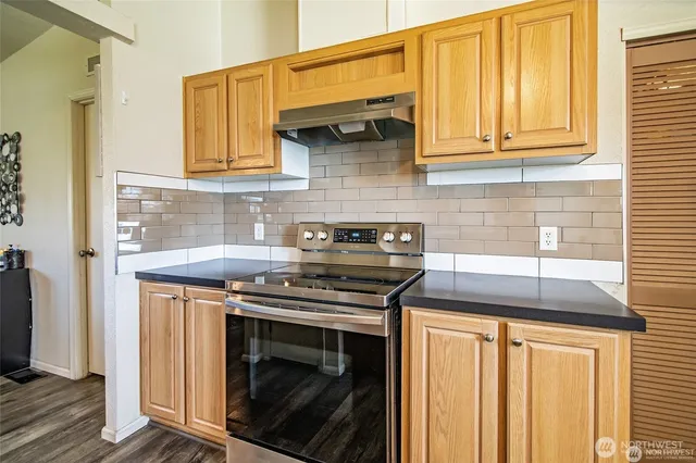 a kitchen with stainless steel appliances granite countertop a stove and a microwave