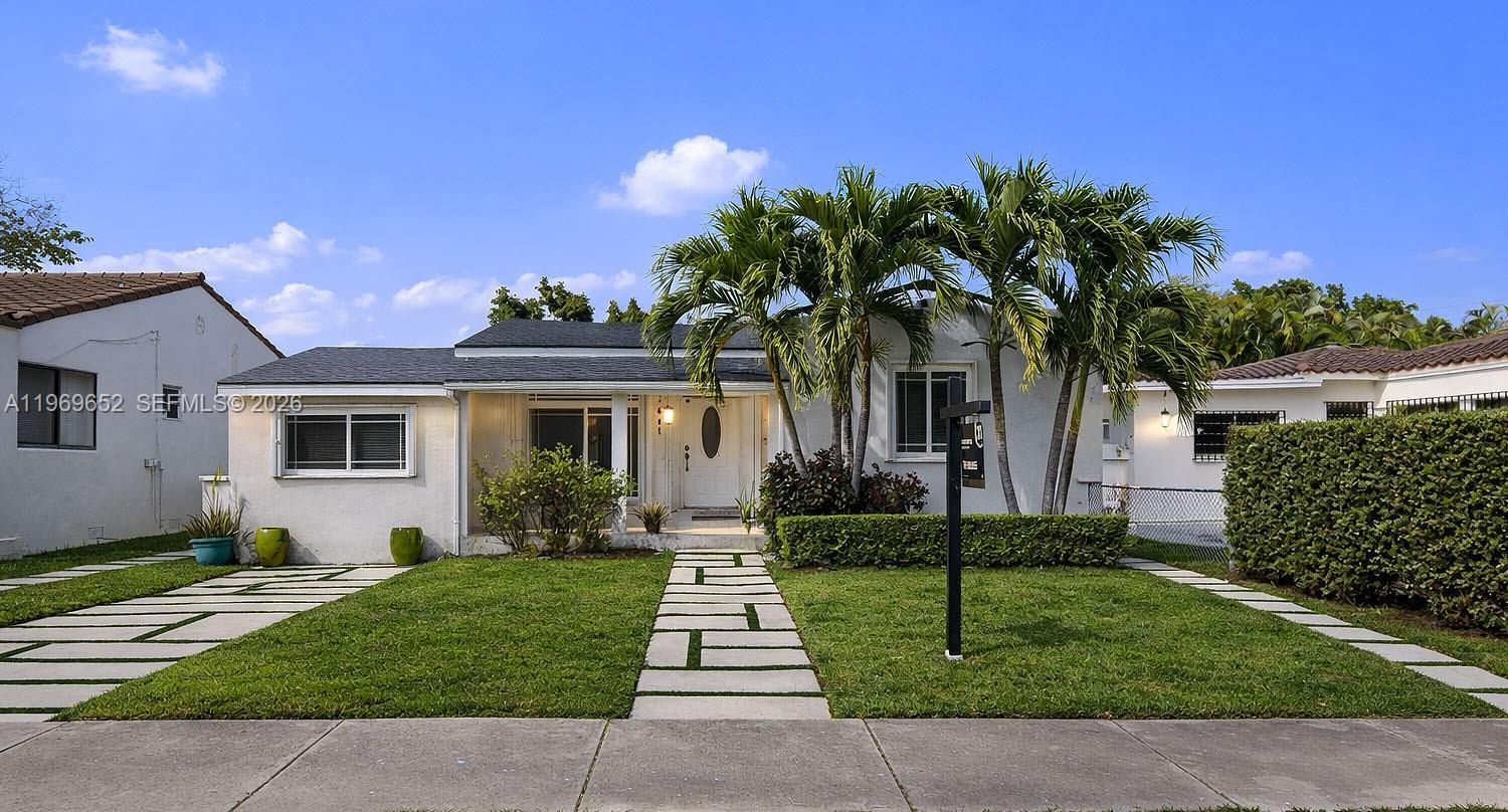 a front view of a house with a garden and yard