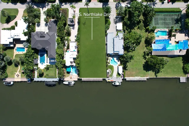 an aerial view of a house with a garden and lake view
