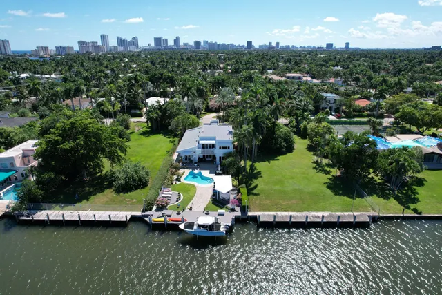 an aerial view of a city with lots of residential buildings ocean and mountain view in back