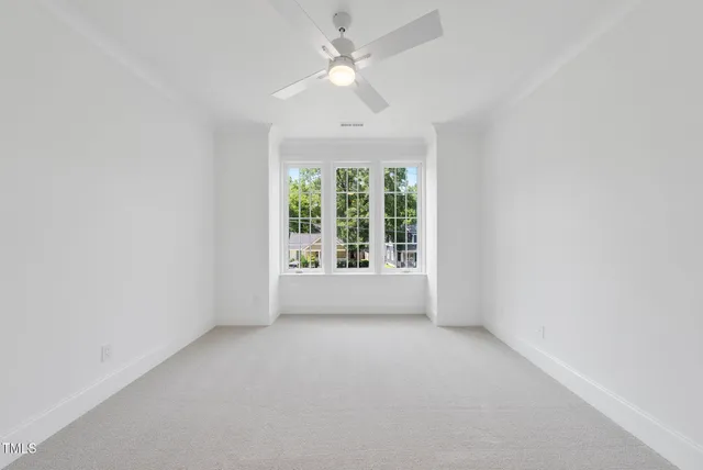 an empty room with a window and a ceiling fan