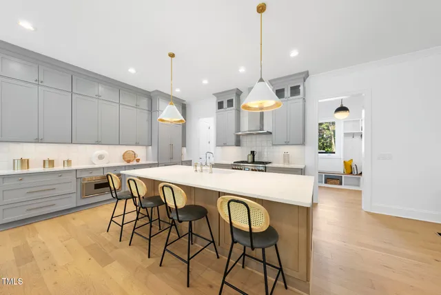 a kitchen with stainless steel appliances kitchen island a chandelier and wooden cabinets
