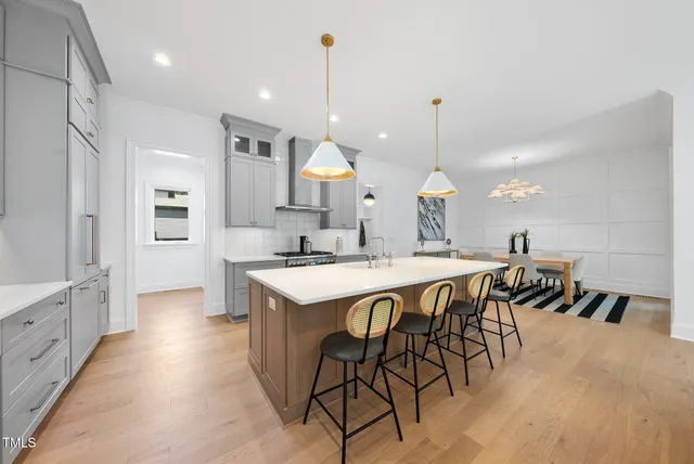 a dining room with wooden floor a chandelier a wooden table and chairs