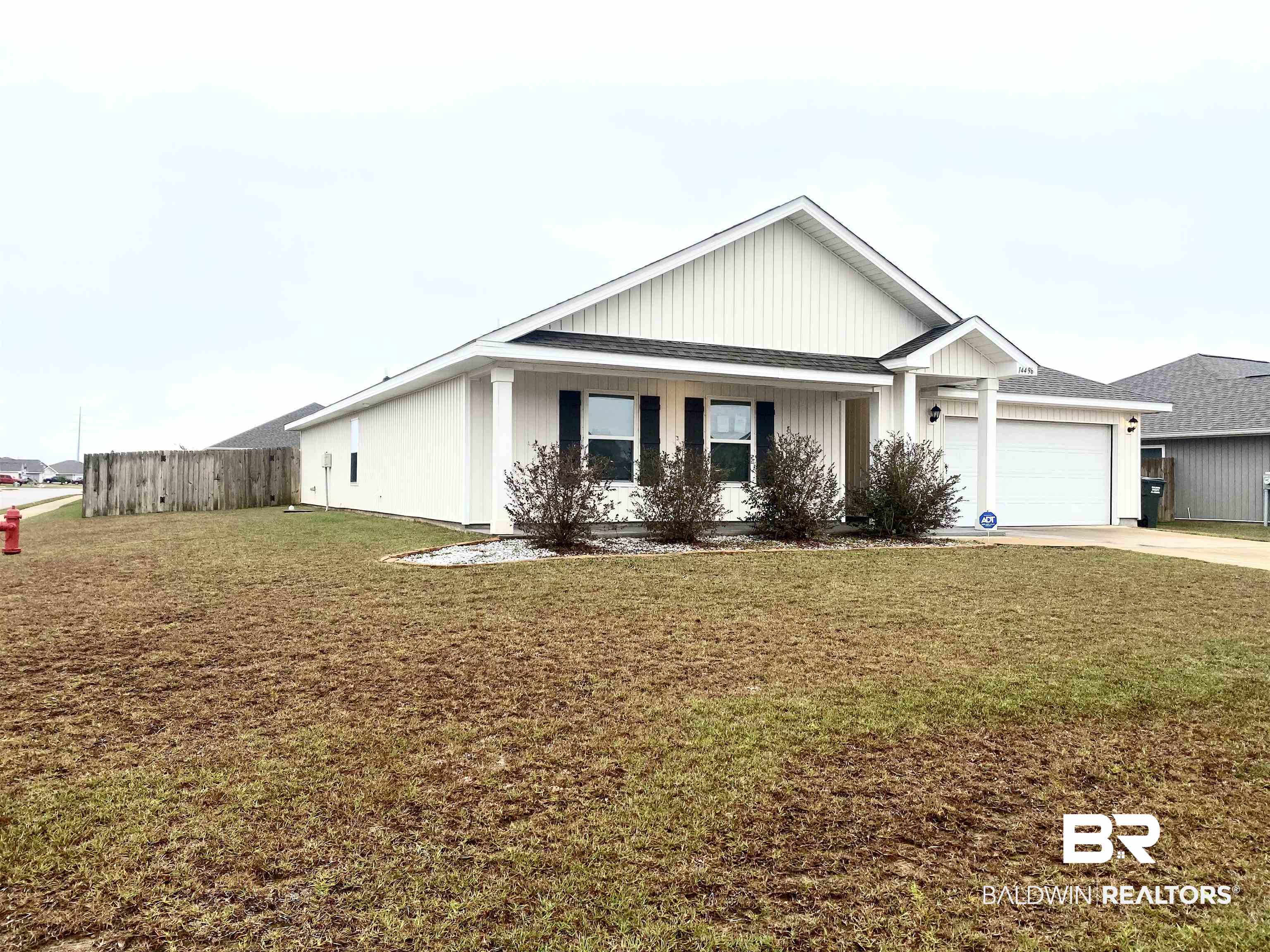 View of front of property featuring a porch, concrete driveway, roof with shingles, and a garage