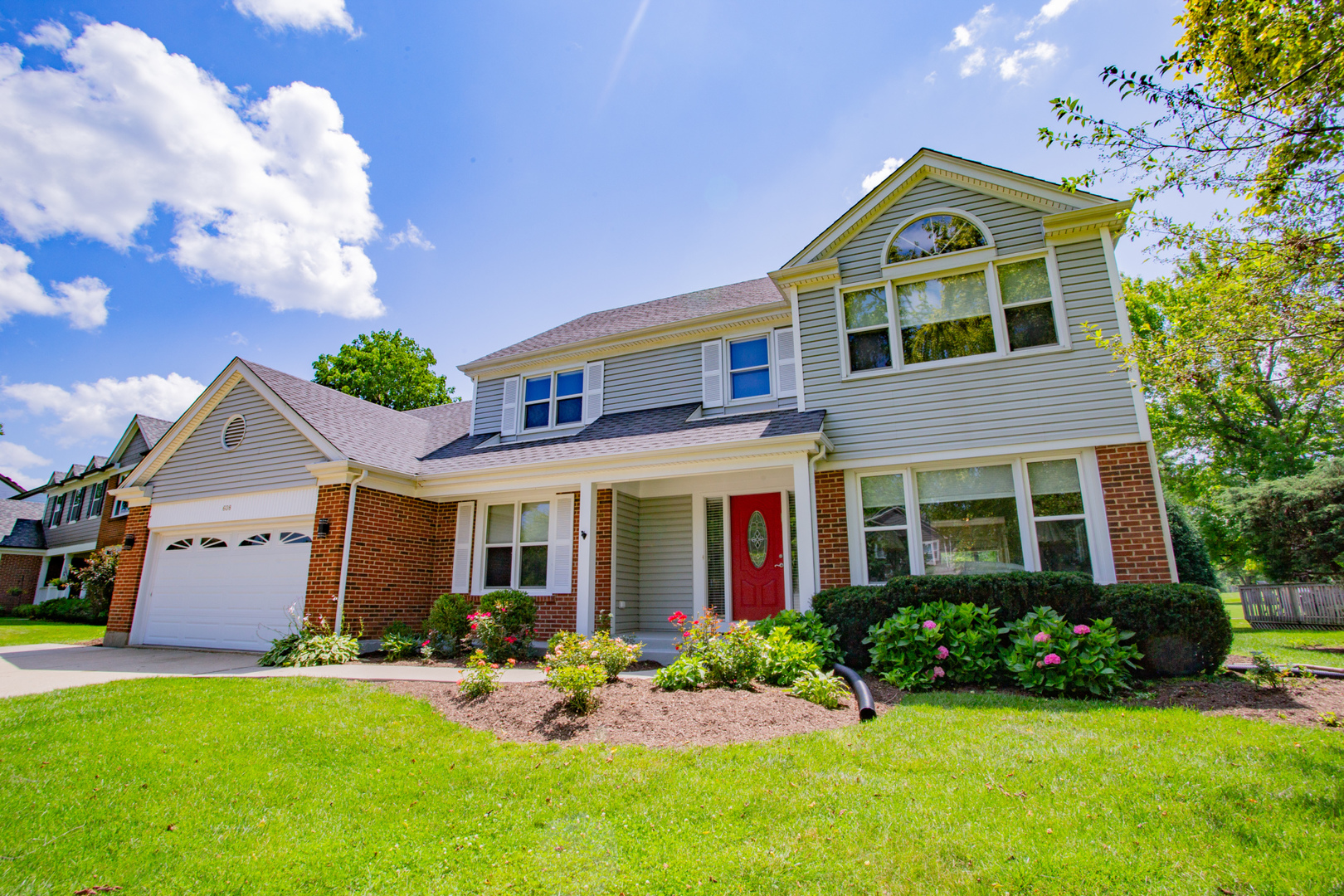 608 Raintree Road Buffalo Grove, IL 60089 - Photo 3 of 59 a front view of a house with a yard and garage