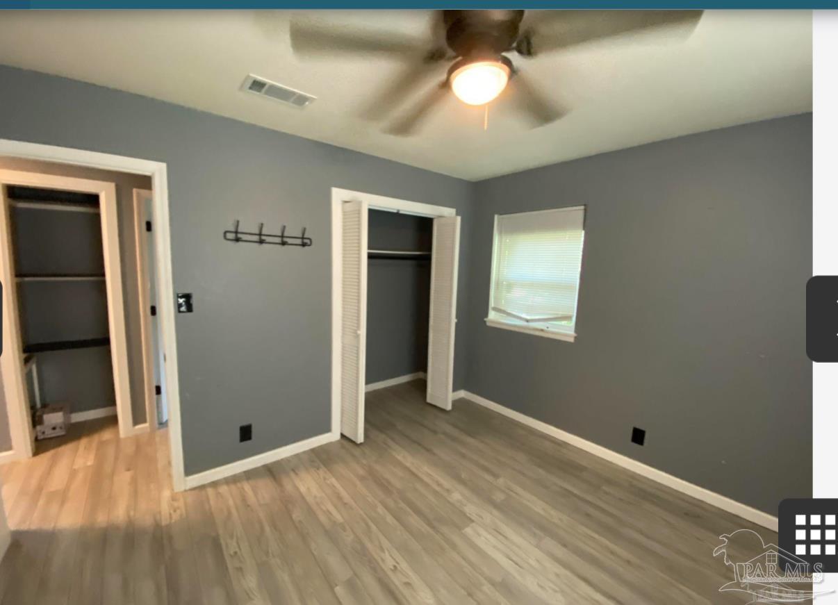 902 Decatur Avenue Pensacola, FL 32507 - Photo 4 of 10 a view of an empty room with wooden floor and a window
