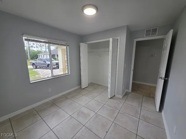 an empty room with windows and closet