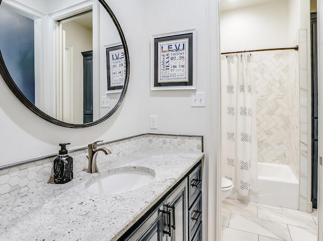 4805 116th Street Lubbock, TX 79424 - Photo 26 of 57 a bathroom with a granite countertop sink and a mirror