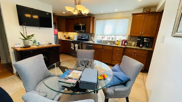 a living room with furniture kitchen view and a flat screen tv