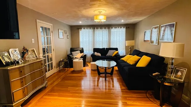 a living room with furniture a lamp wooden floor and a table