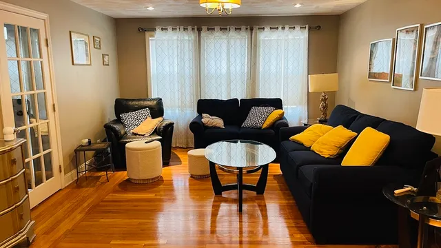 a living room with furniture and a wooden floor