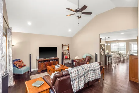 a living room with furniture flat screen tv and wooden floor