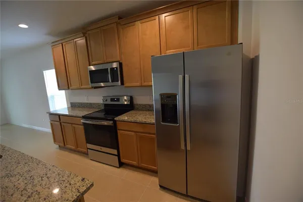 a kitchen with stainless steel appliances granite countertop a refrigerator stove and microwave