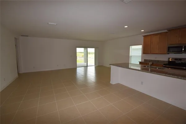 a large kitchen with stainless steel appliances a large counter top a stove and a sink