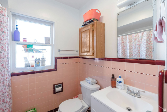654 North 100 East Logan, UT 84321 - Photo 10 of 41 Bathroom with a shower with shower curtain, vanity, wainscoting, and tile walls