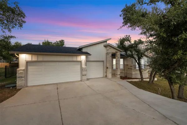 front view of a house with a yard and garage