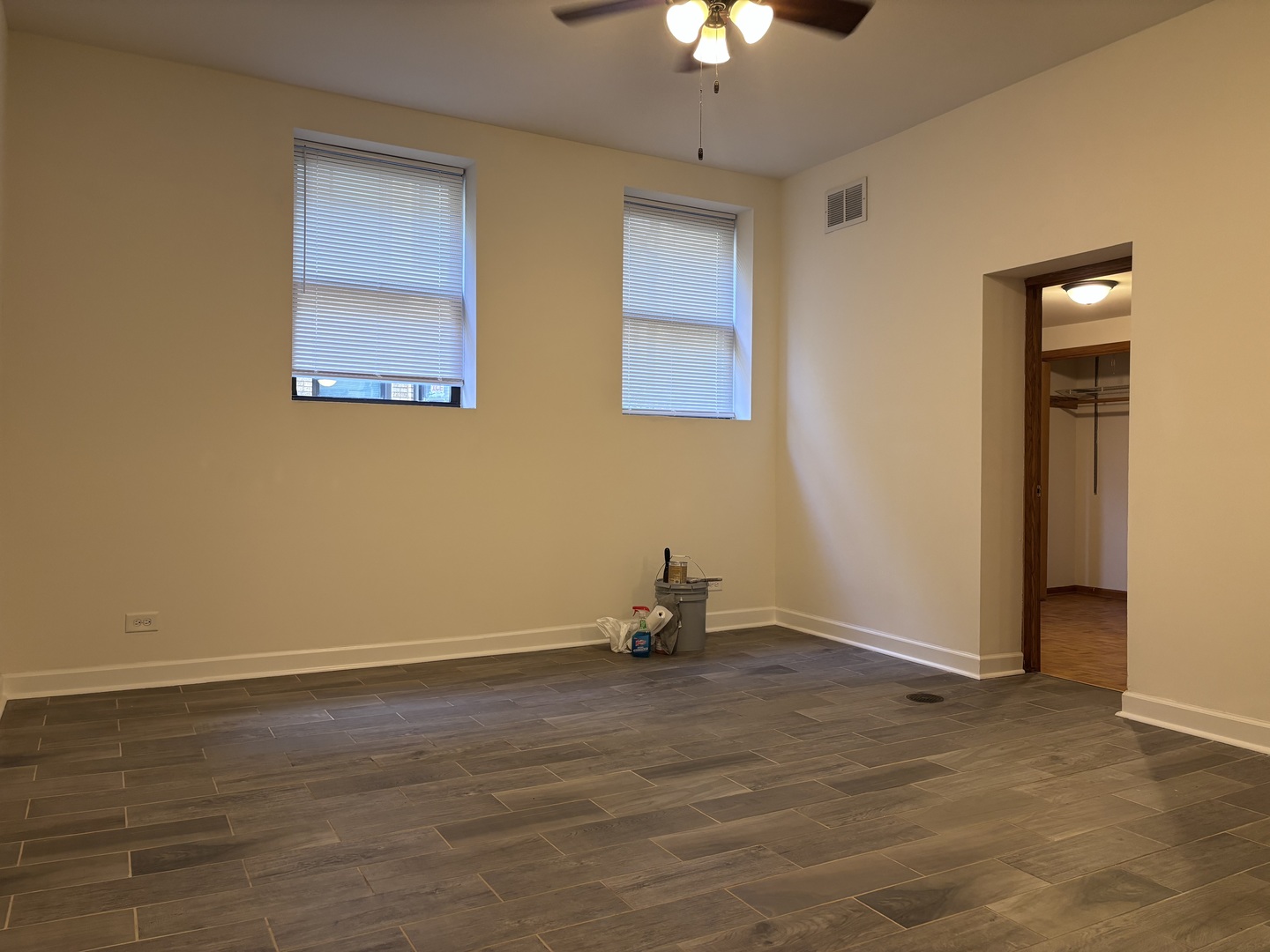 4054 North Sheridan Road, Unit BW Chicago, IL 60613 - Photo 3 of 8 an empty room with a chandelier fan and windows