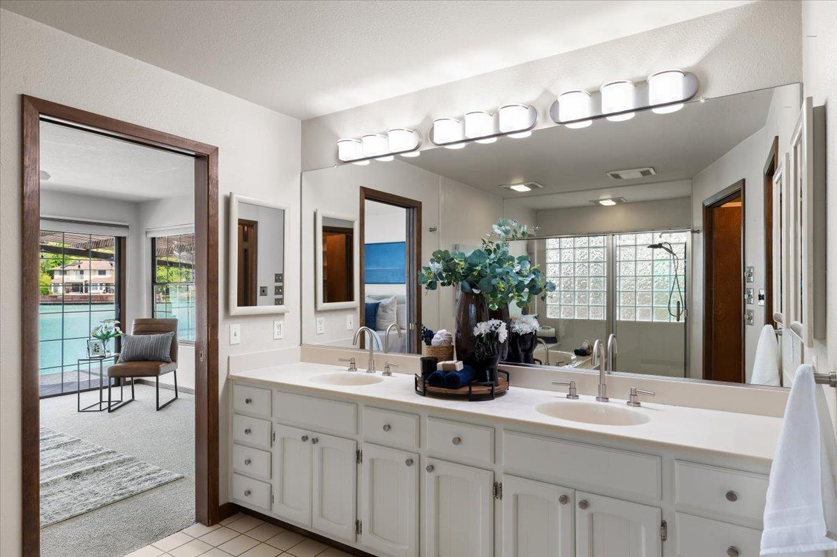 5726 Shelldrake Court Stockton, CA 95207 - Photo 64 of 89 a bathroom with double vanity sinks a large mirror and a shower
