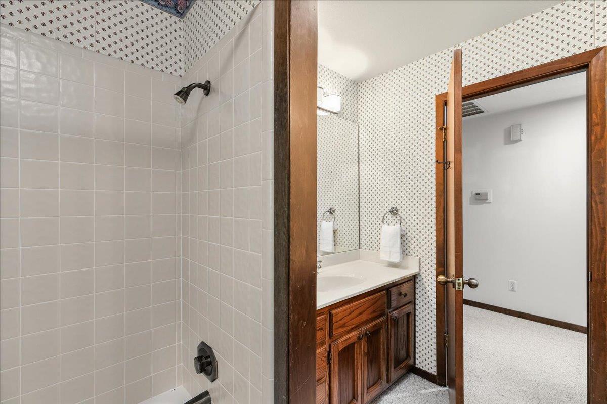 5726 Shelldrake Court Stockton, CA 95207 - Photo 68 of 89 a bathroom with a granite countertop sink a mirror and shower