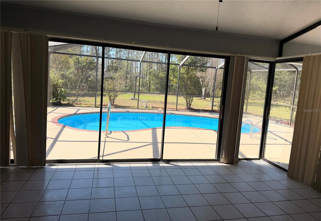 994 East Crown Of Roses Loop Inverness, FL 34453 - Photo 15 of 20 a view of an empty room with a floor to ceiling window and an outdoor view