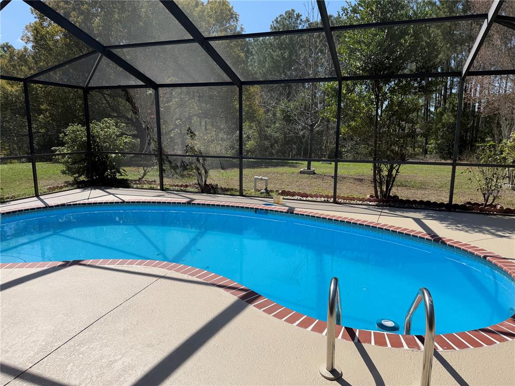 994 East Crown Of Roses Loop Inverness, FL 34453 - Photo 18 of 20 a view of a living room with a floor to ceiling window and wooden floor