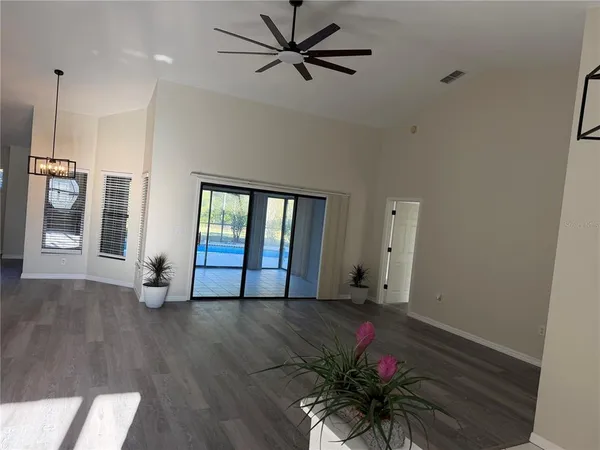 a view of an empty room with a window and wooden floor