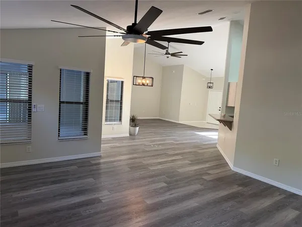 a view of a big room with wooden floor and a ceiling fan