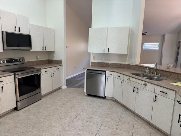 a kitchen with granite countertop white cabinets stainless steel appliances and sink