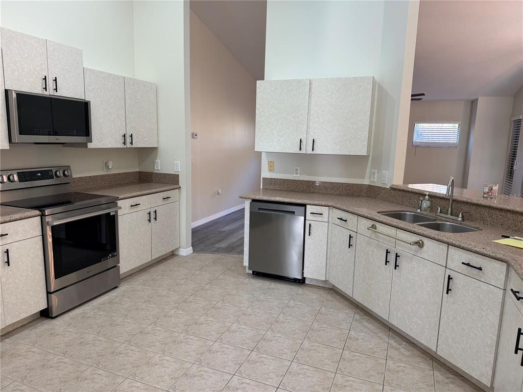 994 East Crown Of Roses Loop Inverness, FL 34453 - Photo 7 of 20 a kitchen with granite countertop white cabinets stainless steel appliances and sink