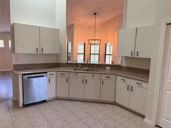 a kitchen with granite countertop white cabinets white appliances with a sink and dishwasher