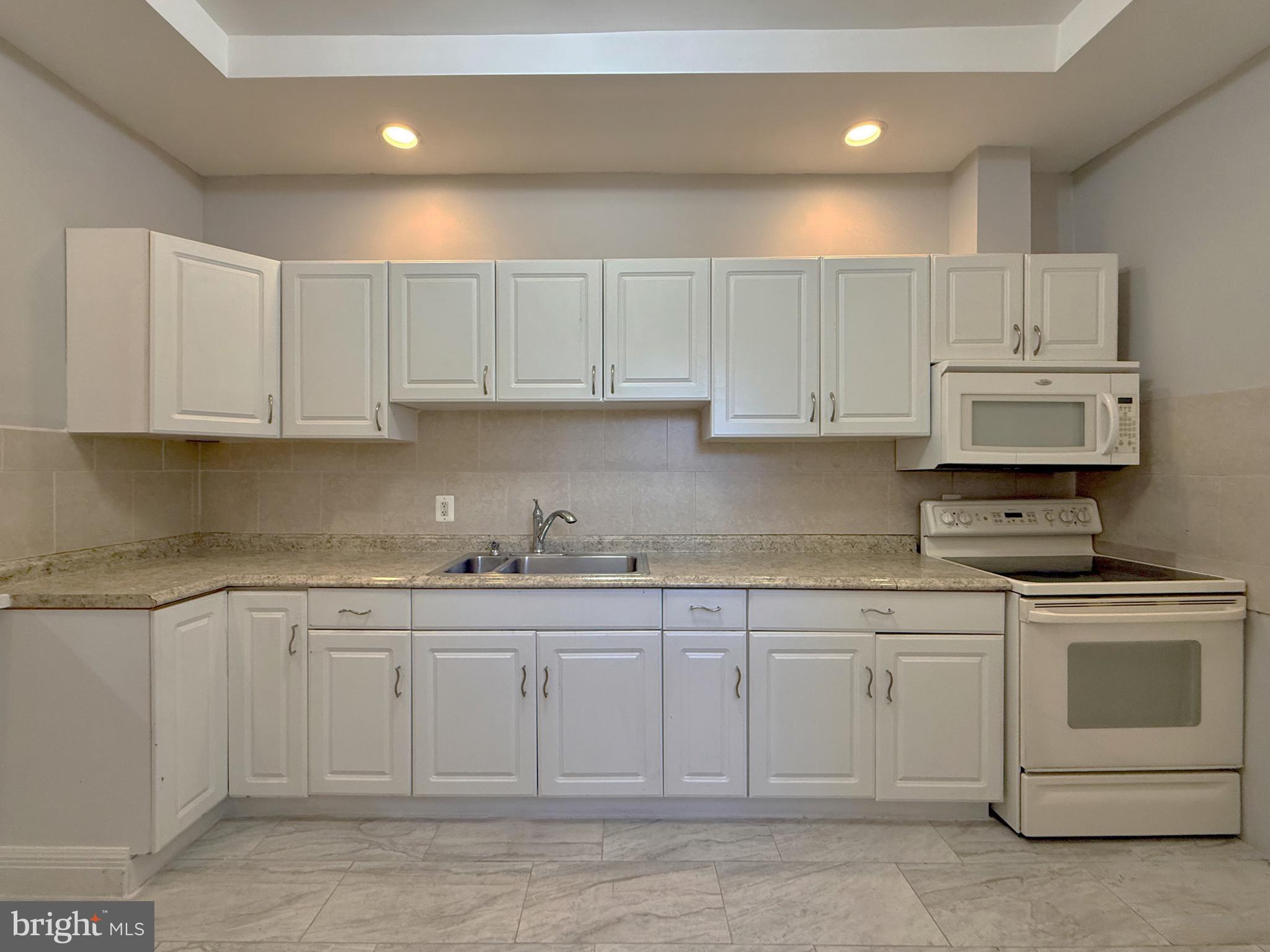 2512 North Front Street Philadelphia, PA 19133 - Photo 4 of 33 a kitchen with white cabinets appliances and sink