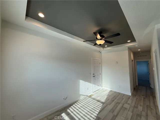 a view of a livingroom with a ceiling fan and wooden floor