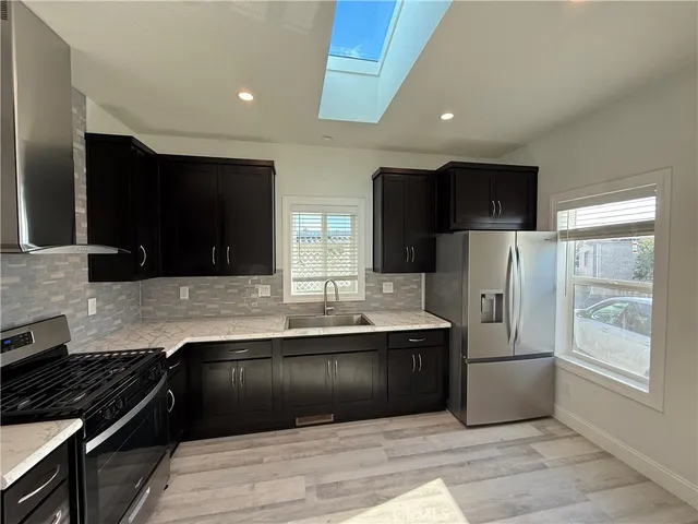 a kitchen with stainless steel appliances granite countertop a refrigerator and a sink