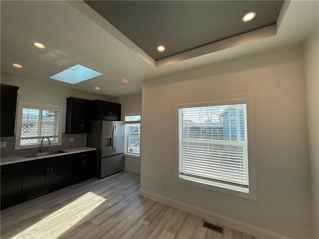 a kitchen with stainless steel appliances kitchen island granite countertop a refrigerator and a sink